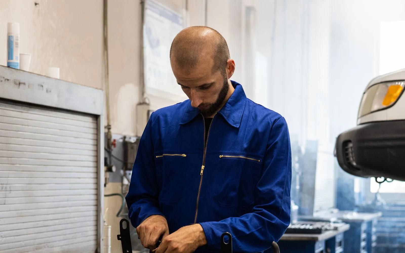 Automotive mechanic inspecting and repairing an engine in a workshop